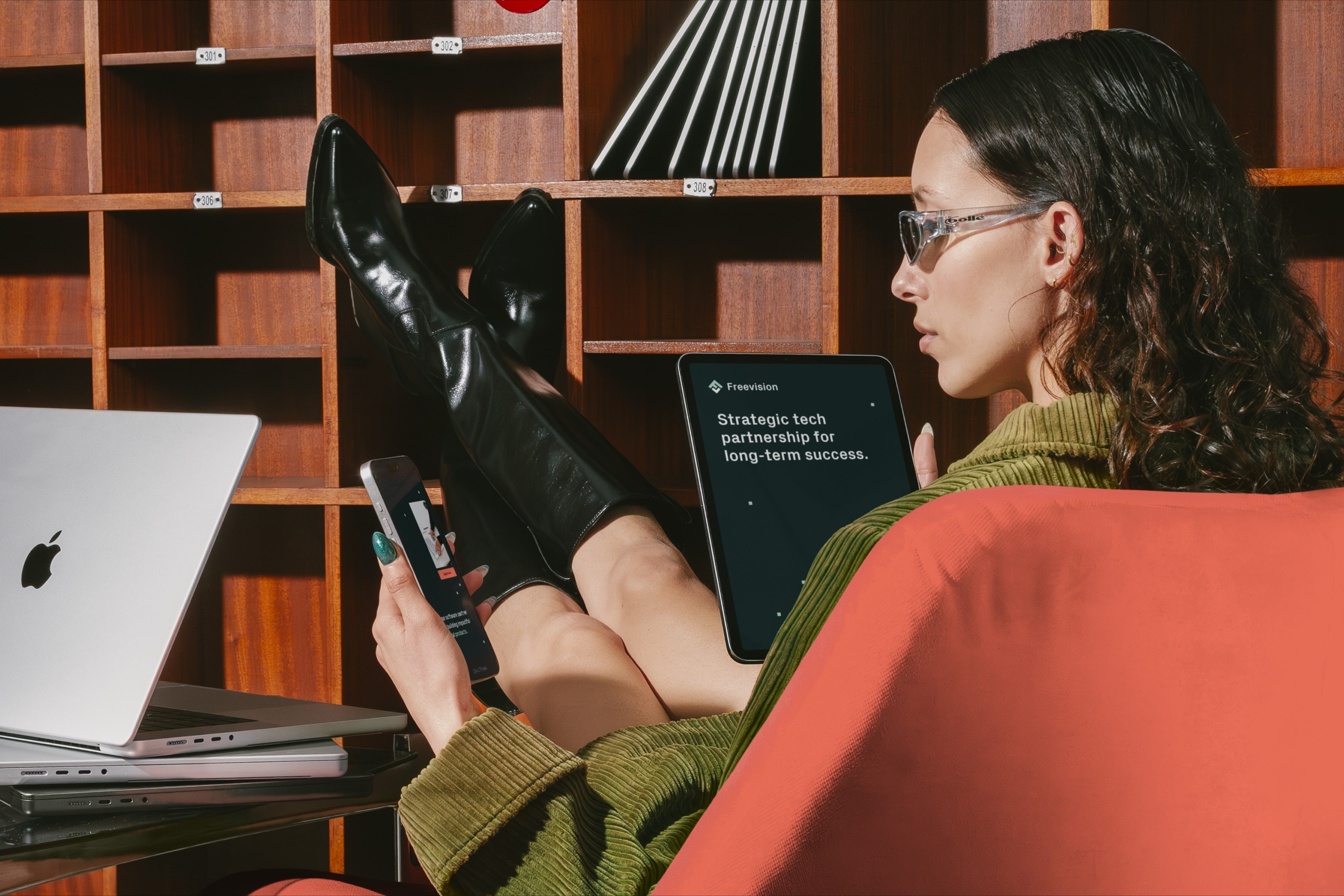 Person on a sofa with a laptop and a Freevision brochure