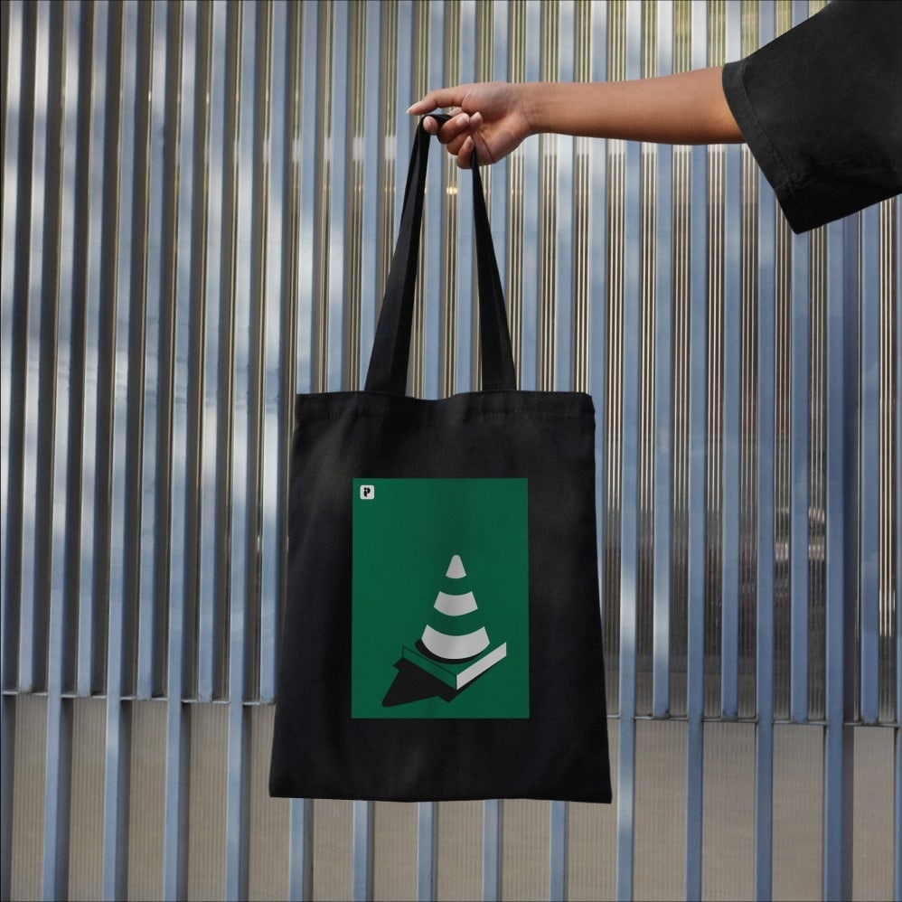 Publiq tote bag held against corrugated metal